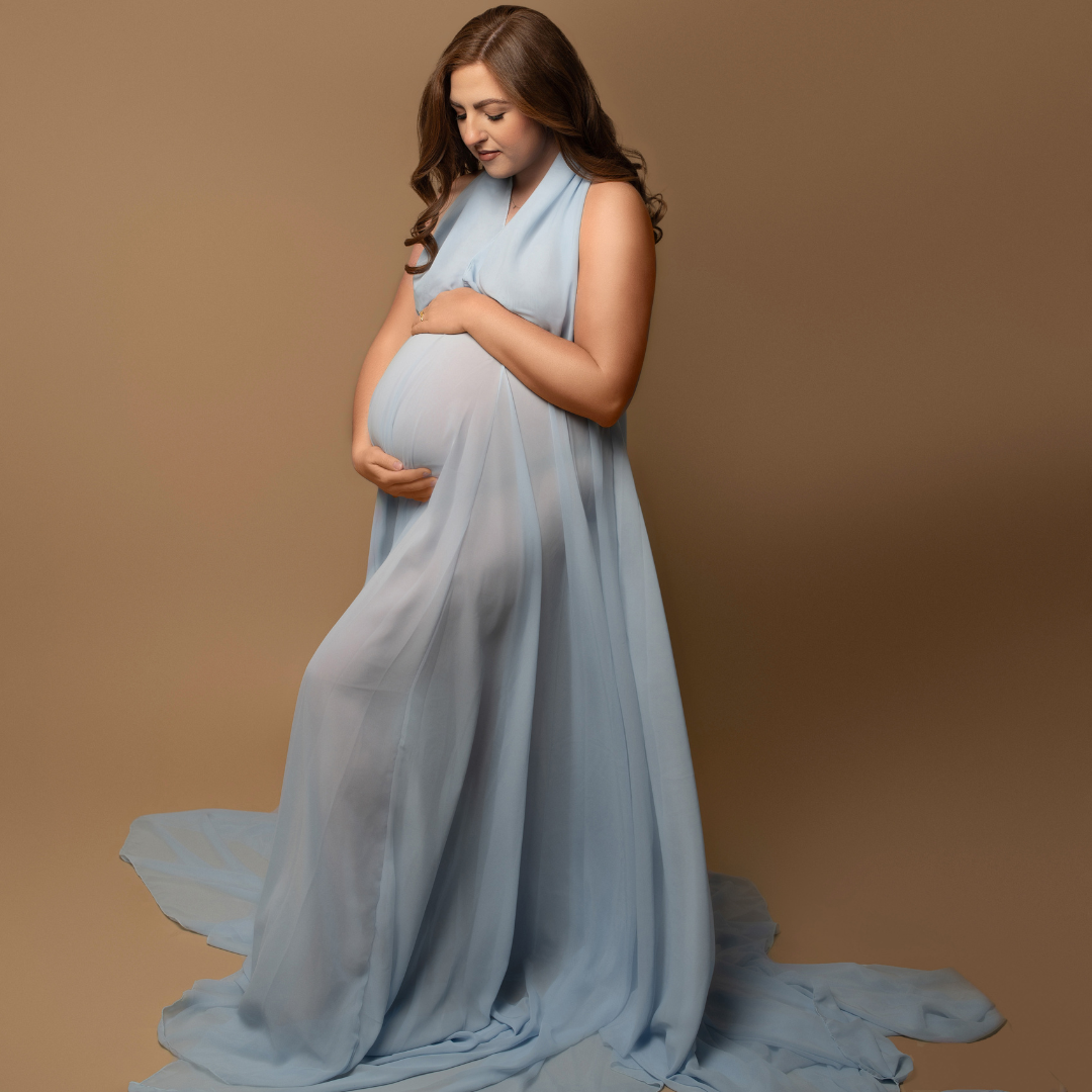 Expecting mom glowing in a beautiful light blue gown during her luxury studio maternity session in Charlotte NC with K Marshay Photography.